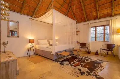 a bedroom with a bed with a canopy in it at South Safari Lodge in Marloth Park