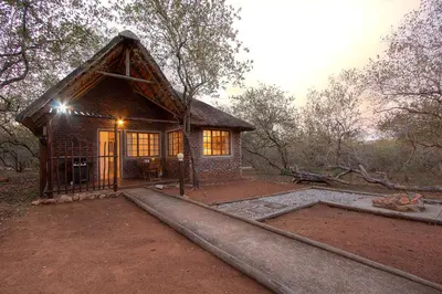 a small house in the middle of a forest at South Safari Lodge in Marloth Park