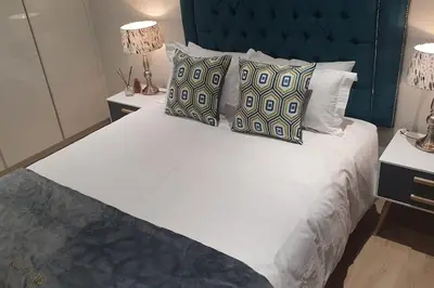 a bedroom with a large white bed with pillows at Ellipse Waterfall - The Loft at Cassini in Midrand
