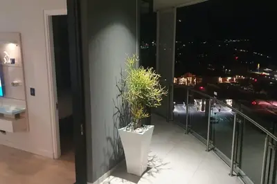 a balcony with a potted plant on the side of a building at Ellipse Waterfall - The Loft at Cassini in Midrand
