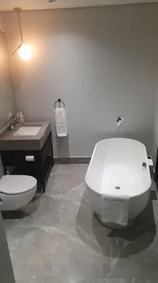 a bathroom with a white toilet and a sink at Ellipse Waterfall - The Loft at Cassini in Midrand