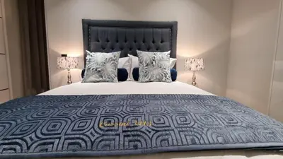 a bedroom with a large bed with two lamps at Ellipse Waterfall - The Loft at Cassini in Midrand