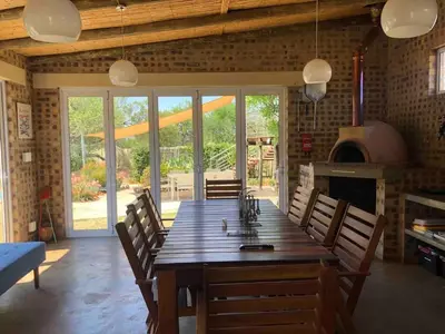 a dining room with a large wooden table and a fireplace at 46 Welgevonden in Dinokeng in Dinokeng Game Reserve