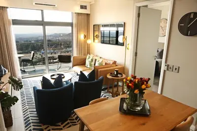 a living room with a table and chairs at Menlyn Trilogy - 2 Bedroom & Great Views - No Loadshedding in Pretoria