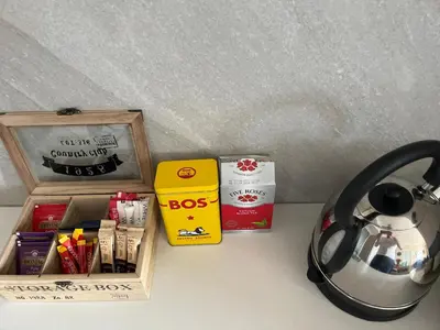 a table with a tea kettle and a box of books at Menlyn Trilogy - 2 Bedroom & Great Views - No Loadshedding in Pretoria