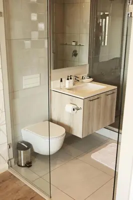 a bathroom with a toilet and a glass shower at Menlyn Trilogy - 2 Bedroom & Great Views - No Loadshedding in Pretoria