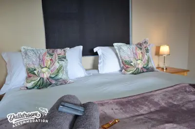 a bedroom with a bed with pillows at Uitzicht in Dullstroom