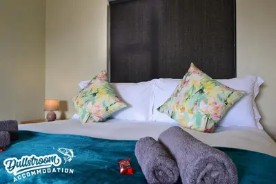 a bed with pillows and towels on top of it at Uitzicht in Dullstroom