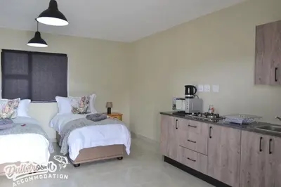 a bedroom with two beds and a sink in it at Uitzicht in Dullstroom