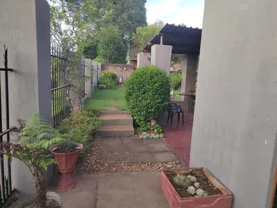 a garden with plants and a fence and a patio at 83 on De Lange in Graskop
