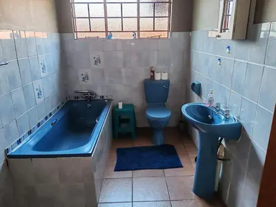 a bathroom with a tub and a toilet and a sink at 83 on De Lange in Graskop