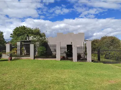 a building behind a fence in a yard at 83 on De Lange in Graskop