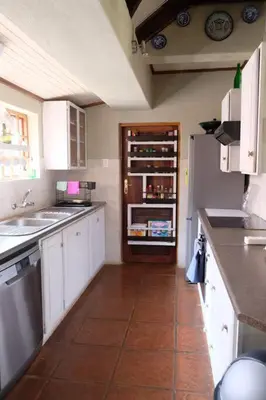 a kitchen with white cabinets and a refrigerator at Eden Rain in Dullstroom