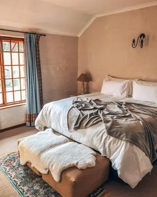a bedroom with a large bed and a window at Eden Rain in Dullstroom