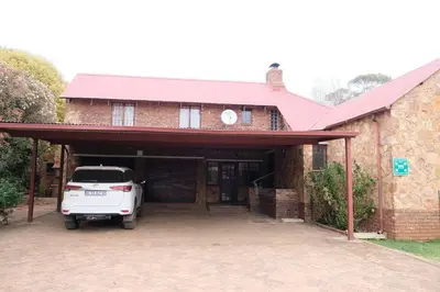 a white car parked in the garage of a brick house at Eden Rain in Dullstroom