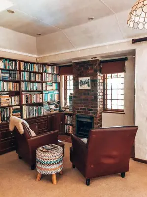 a living room with two chairs and a fireplace at Eden Rain in Dullstroom