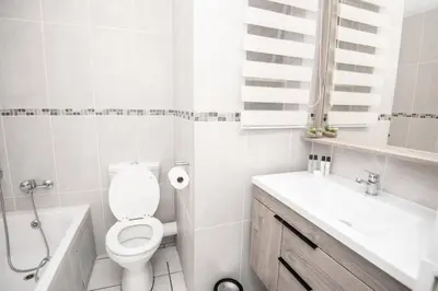 a white bathroom with a toilet and a sink at Unit 416 at Menlyn Place in Pretoria