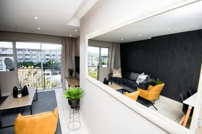 a living room with a couch and a table and chairs at Unit 416 at Menlyn Place in Pretoria