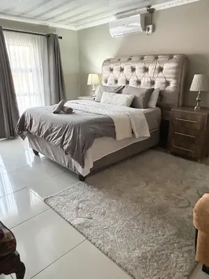 a bedroom with a large bed and a rug at Mjejane Debs guest house in Hectorspruit