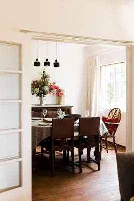 a dining room with a table and chairs at Verkijken Cottage in Haenertsburg