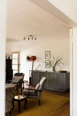 a living room with two chairs and a table at Verkijken Cottage in Haenertsburg