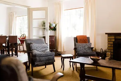 a living room with chairs and a table at Verkijken Cottage in Haenertsburg