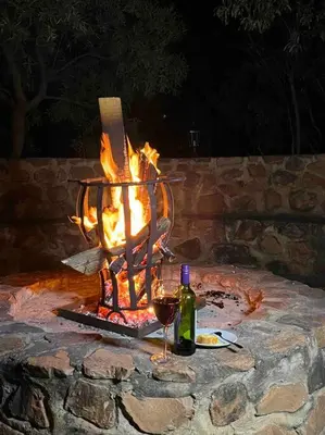 a fire pit with a bottle of wine and a glass at Hakuna Matata-Bela Bela in Moheme
