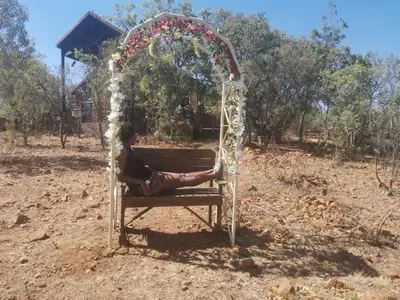 a woman sitting on a bench under an arch at Hakuna Matata-Bela Bela in Moheme