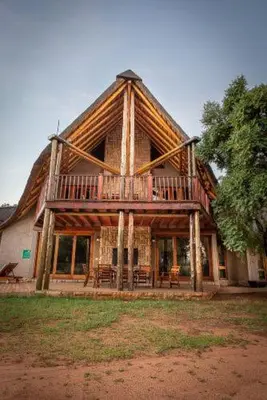 a large log house with a deck on the front at 23 Zebula - 4 Bedroom 14 Sleeper Home in Mabula