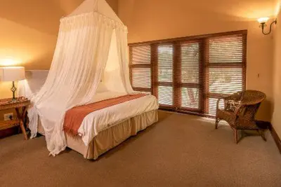 a bedroom with a bed with a mosquito net at 23 Zebula - 4 Bedroom 14 Sleeper Home in Mabula
