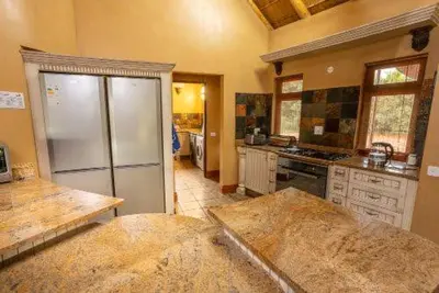 a kitchen with a refrigerator and a counter top at 23 Zebula - 4 Bedroom 14 Sleeper Home in Mabula