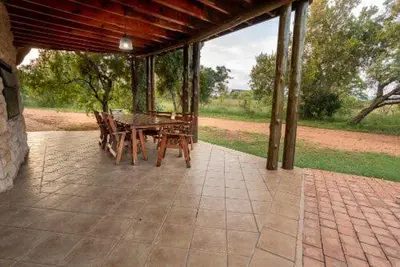 a patio with a table and chairs on it at 23 Zebula - 4 Bedroom 14 Sleeper Home in Mabula