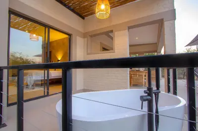 a bath tub on the balcony of a house at MRLTH Luxury Safari Villa, Close to KNP, Giraffe-Feeding-Tower, Spa-Bath, Boma in Marloth Park