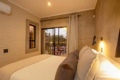 a bedroom with a bed and a large window at MRLTH Luxury Safari Villa, Close to KNP, Giraffe-Feeding-Tower, Spa-Bath, Boma in Marloth Park
