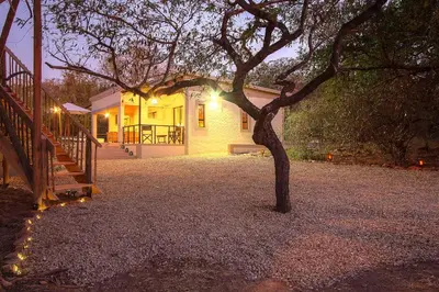 a tree in front of a house with lights at MRLTH Luxury Safari Villa, Close to KNP, Giraffe-Feeding-Tower, Spa-Bath, Boma in Marloth Park