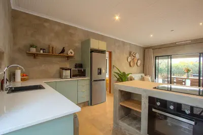 a kitchen with a sink and a counter top at MRLTH Luxury Safari Villa, Close to KNP, Giraffe-Feeding-Tower, Spa-Bath, Boma in Marloth Park