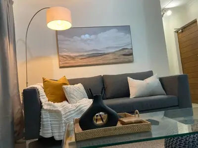 a living room with a couch and a glass table at Luxury 1bed Serengeti OliveWood ORT Airport in Kempton Park