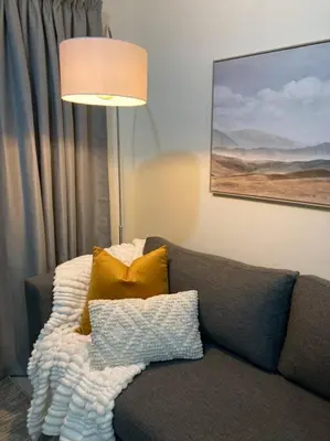 a living room with a couch with pillows and a lamp at Luxury 1bed Serengeti OliveWood ORT Airport in Kempton Park