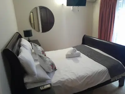 a bed with pillows and a mirror in a room at Mountain Vue in Hartbeespoort
