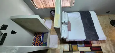 a small room with a bed and a sink at Mountain Vue in Hartbeespoort