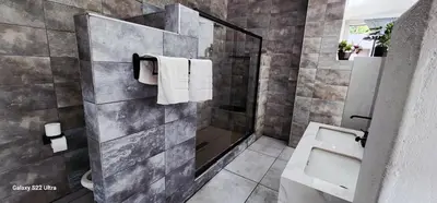 a bathroom with a shower and a toilet and towels at Mountain Vue in Hartbeespoort