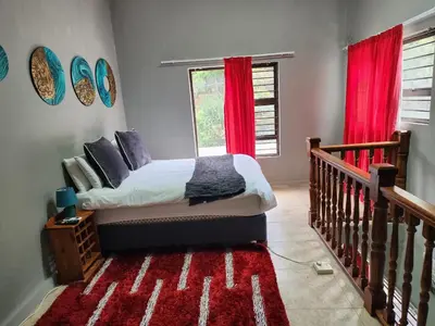a bedroom with a bed and a red window at Mountain Vue in Hartbeespoort