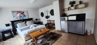 a bedroom with a bed and a table in it at Mountain Vue in Hartbeespoort