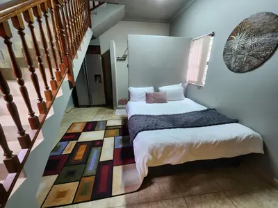 a bedroom with a bed next to a staircase at Mountain Vue in Hartbeespoort