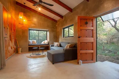 a living room with a couch and a window at Ibhubesi house in Marloth Park