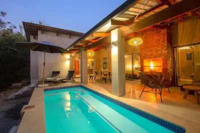 a swimming pool in front of a house at Ibhubesi house in Marloth Park