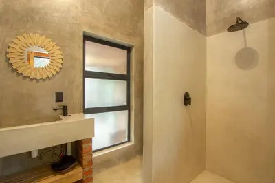a bathroom with a sink and a mirror and a window at Ibhubesi house in Marloth Park