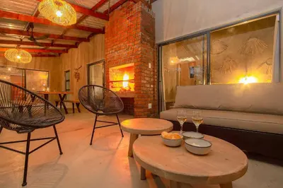 a living room with two tables and chairs and a couch at Ibhubesi house in Marloth Park