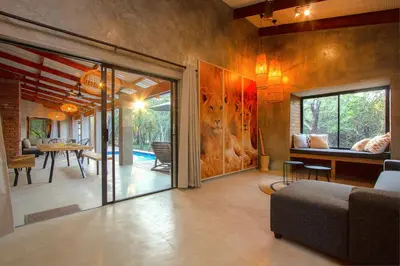a living room with sliding glass doors and a dining room at Ibhubesi house in Marloth Park