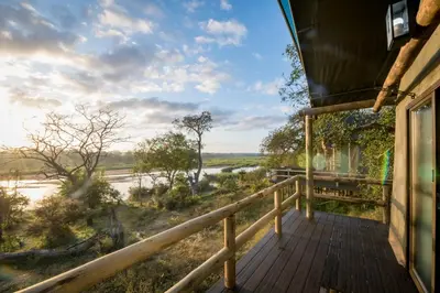 a balcony of a house with a view of a river at Nkuhlu Tented Camp in Skukuza
